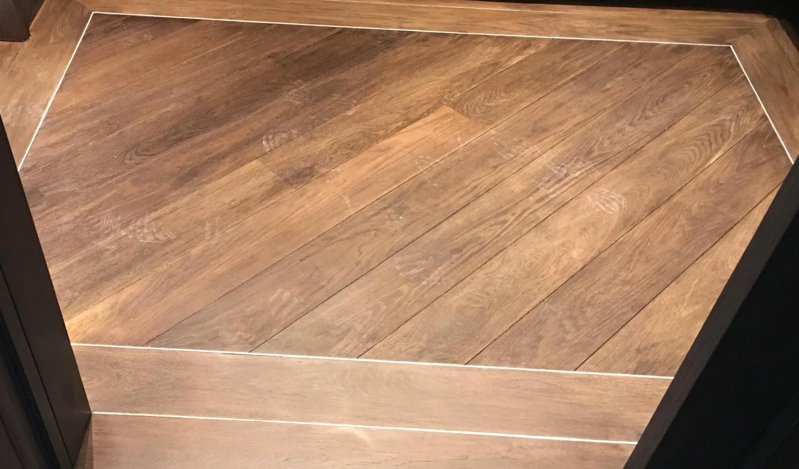Engineered smoke oak - plank stainless steel trim inlay boarder work.